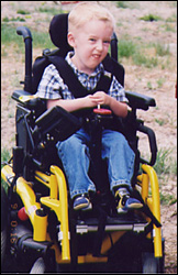 Boy strapped into a motorized wheelchair